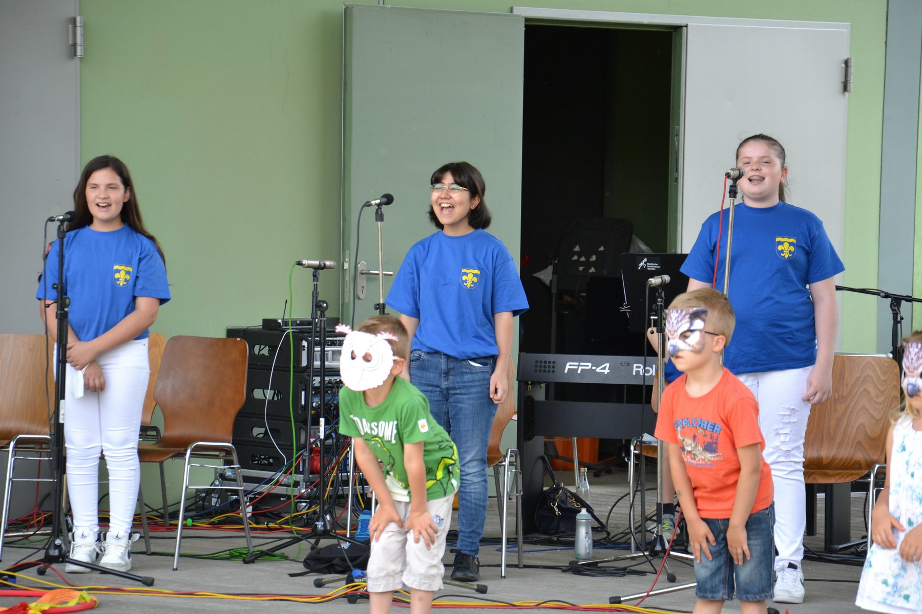 Drei Sängerinnen und zwei Kinder der musikalischen Früherziehung mit Eulenmasken